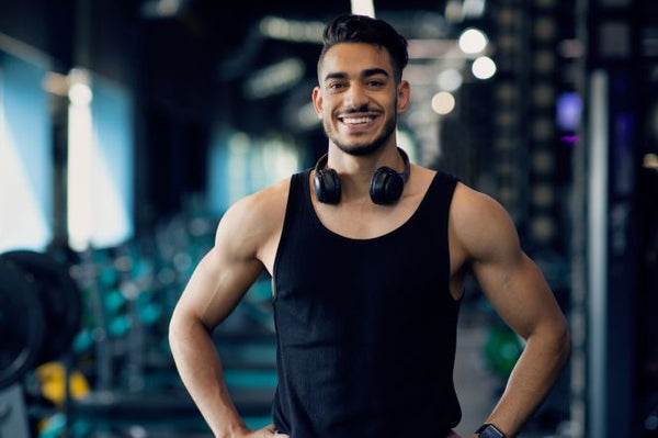 Fitness enthusiast with headphones, smiling at the gym